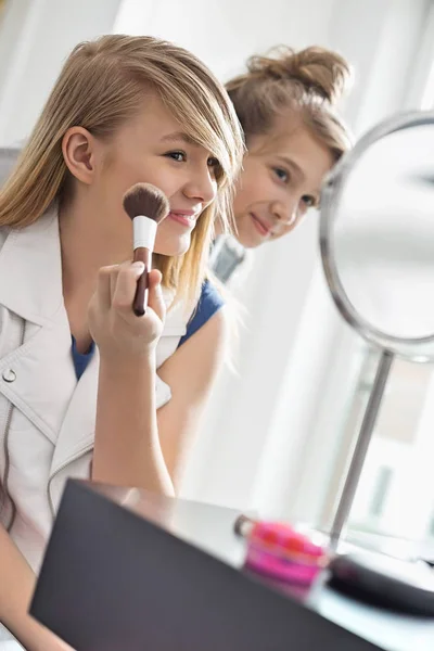 Flickan tittar på syster tillämpa makeup — Stockfoto