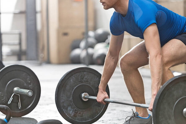 Выделенный человек поднимает штангу
