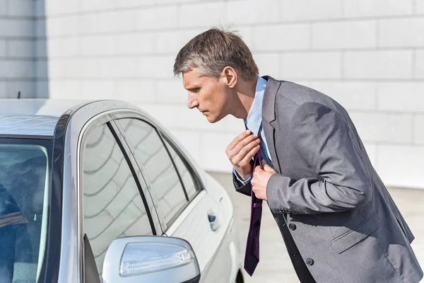 Businessman adjusting tie — Stock Photo, Image