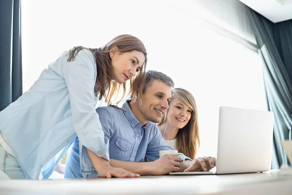 Ouders met dochter met behulp van laptop — Stockfoto