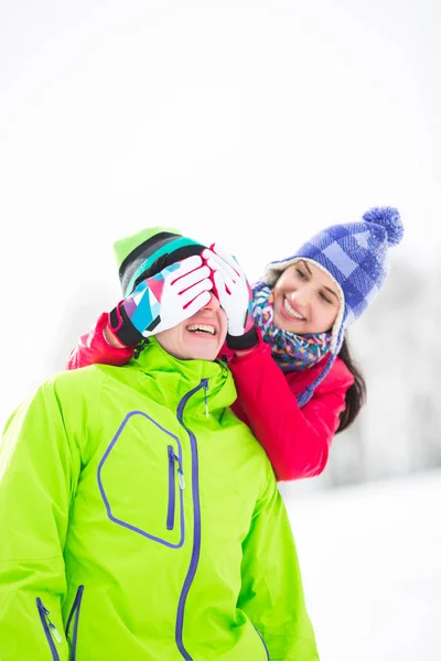 Woman covering man's eyes in winter — Stock Photo, Image