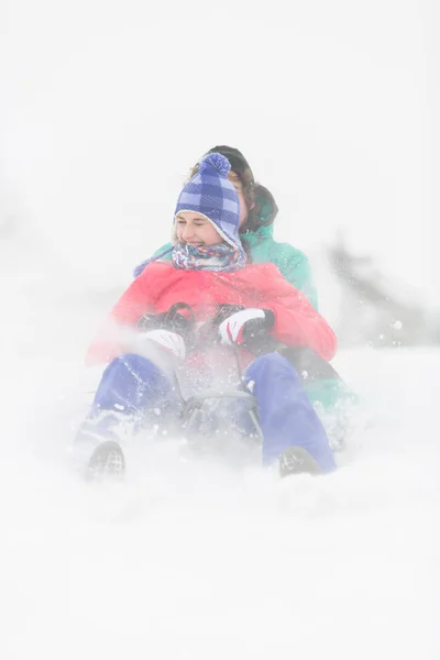 Couple sledding in snow — Stock Photo, Image