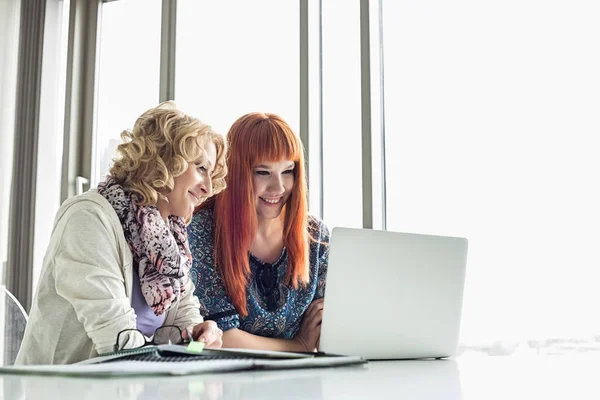 Leende affärskvinnor med laptop — Stockfoto