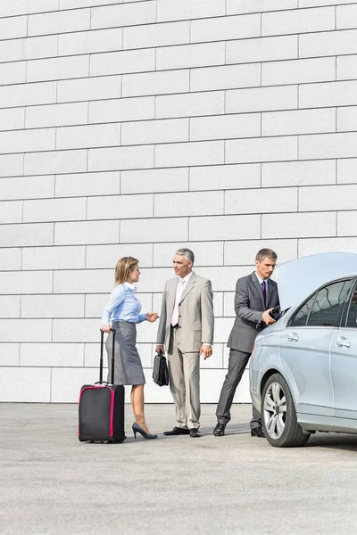 Businesspeople with luggage communicating — Stock Photo, Image