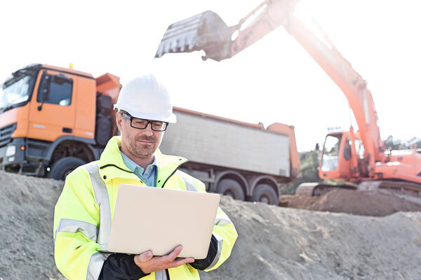 Supervisor using laptop at construction site