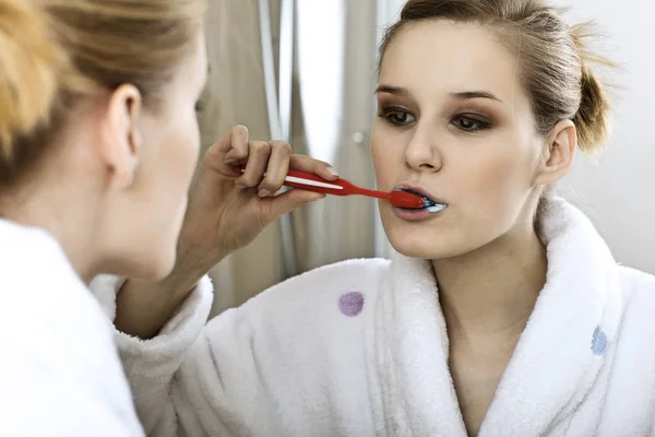 Mujer en baño cepillándose los dientes — Foto de Stock