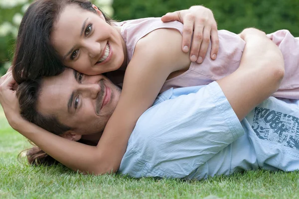 Pareja abrazando mientras mintiendo — Foto de Stock