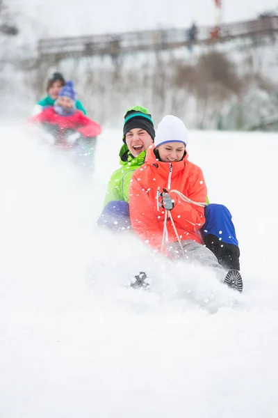 Couples enjoying sled ride — Stock Photo, Image