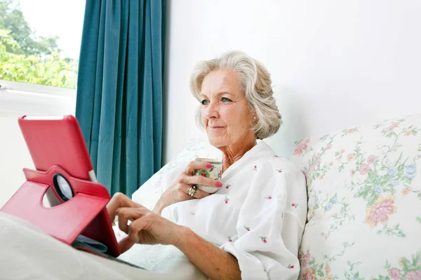 Dijital tablet kullanan yaşlı kadın — Stok fotoğraf