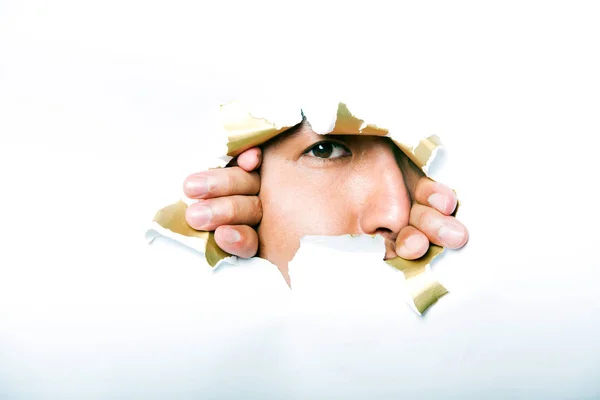 Man looking through paper hole Stock Picture