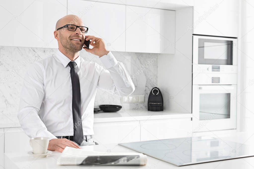 Businessman on call at kitchen