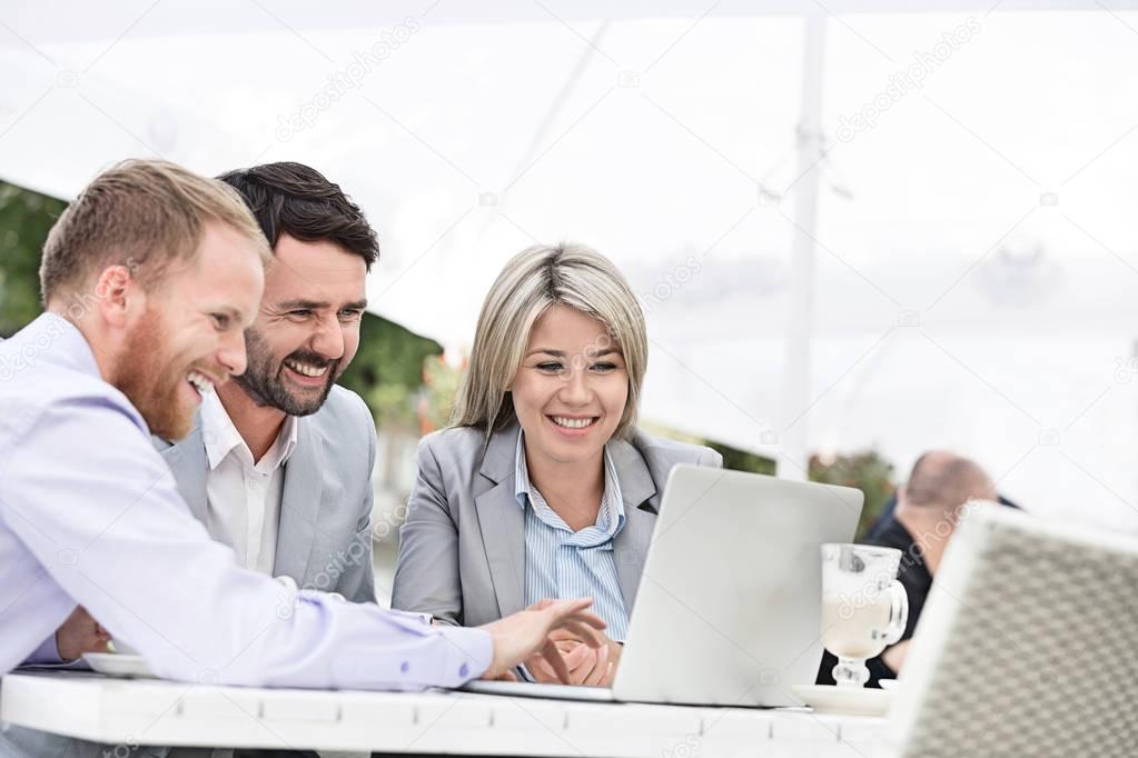 Happy businesspeople using laptop