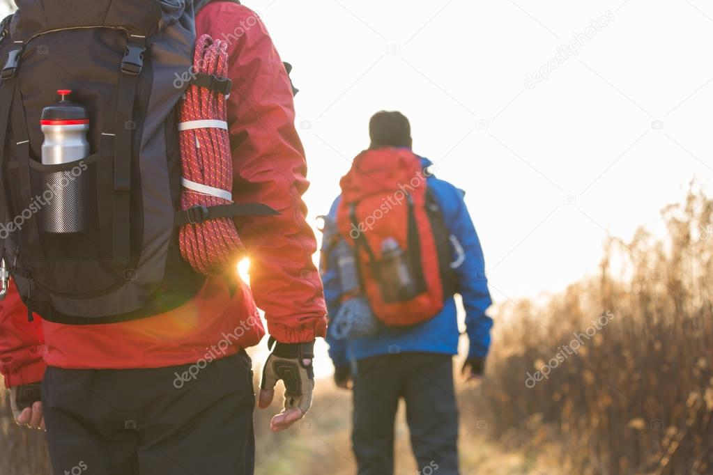 backpackers walking in field