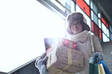 Yığılmış hediyeler ile gülümseyen kadın 