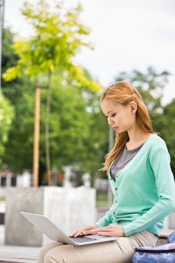 Dizüstü bilgisayar kullanan genç kadın 