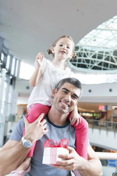 Meisje zit op vaders schouders — Stockfoto