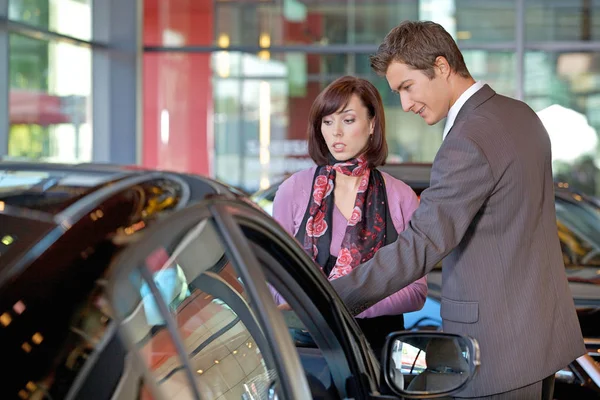 Vendeur expliquant les caractéristiques de la voiture au client — Photo