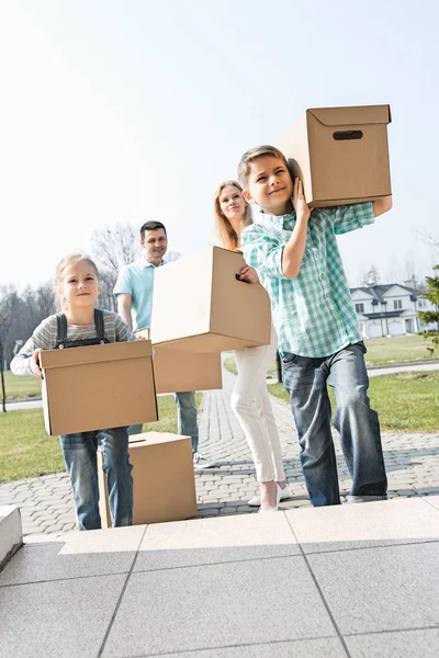 Family carrying cardboard boxes — Stock Photo, Image
