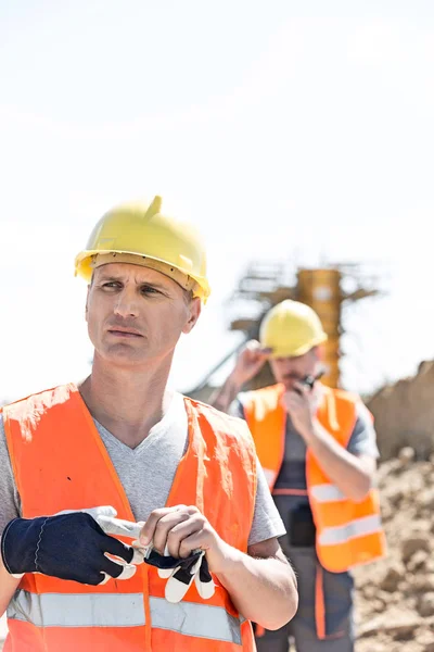 Düşünceli işçi inşaat alanında ayakta — Stok fotoğraf
