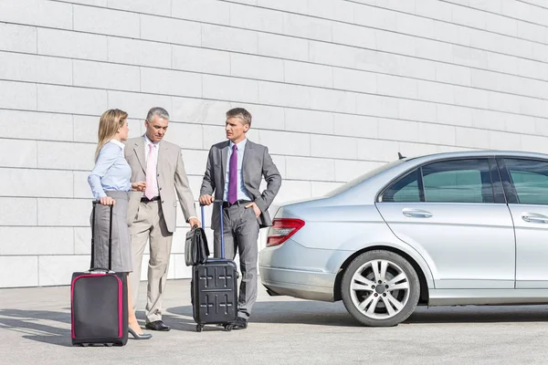 Businesspeople with luggage discussing — Stock Photo, Image