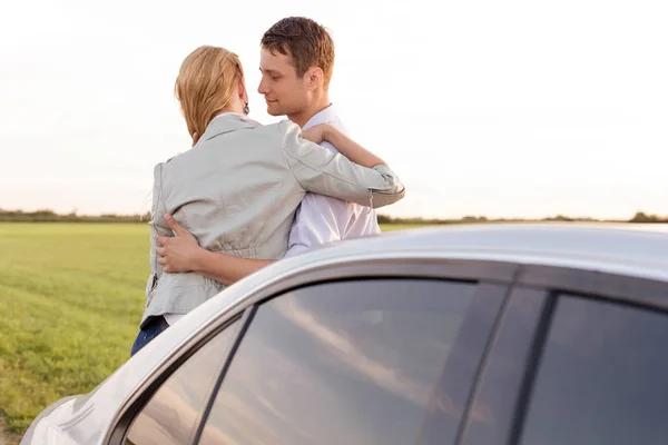 Casal romântico apoiando-se no carro — Fotografia de Stock