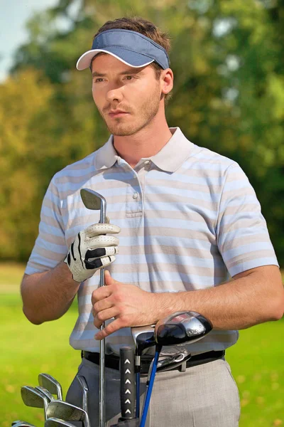 Young man standing by golf bag — Stock Photo, Image