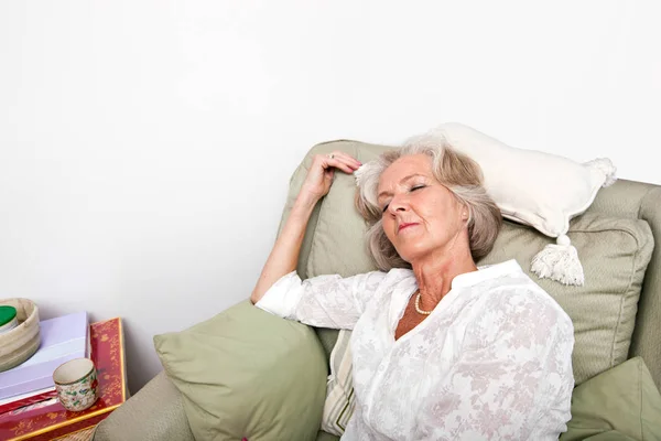 Senior Kvinna sover på fåtölj — Stockfoto