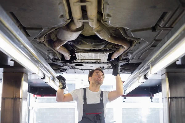 Arbeiter repariert Auto in Werkstatt — Stockfoto
