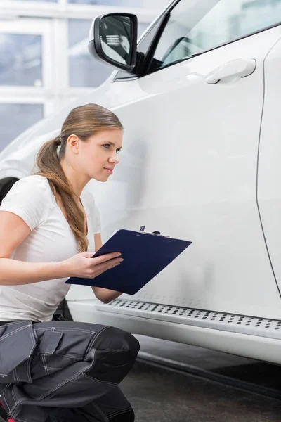 Mechanic examining car body — Stock Photo, Image