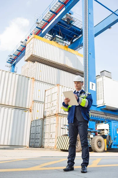 Männlicher Vorgesetzter schreibt auf Klemmbrett — Stockfoto