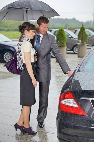 Homme ouvrant la porte de la voiture pour femme — Photo