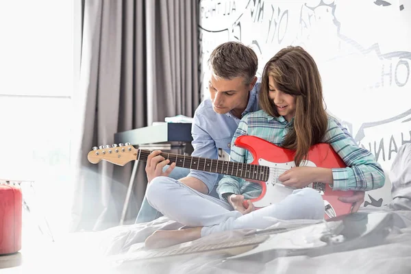 Padre enseñando a hija a tocar la guitarra — Foto de Stock