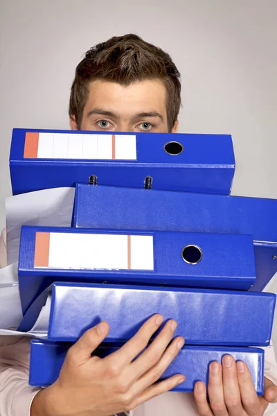 Businessman holding a stack of binders — Stock Photo, Image