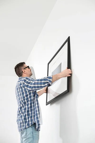 Man positioning picture frame — Stock Photo, Image