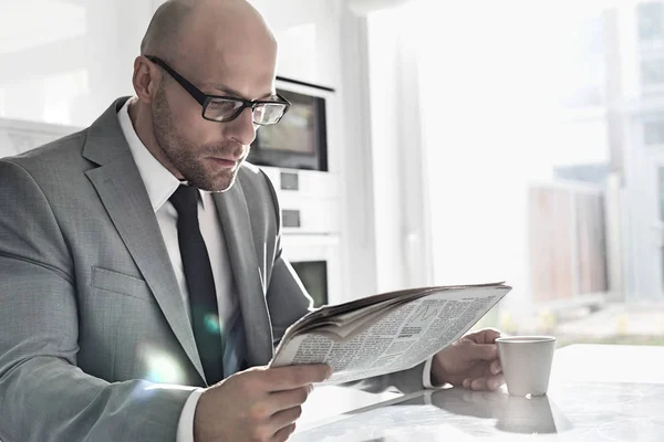 Affärsman med kopp kaffe medan du läser tidningen — Stockfoto