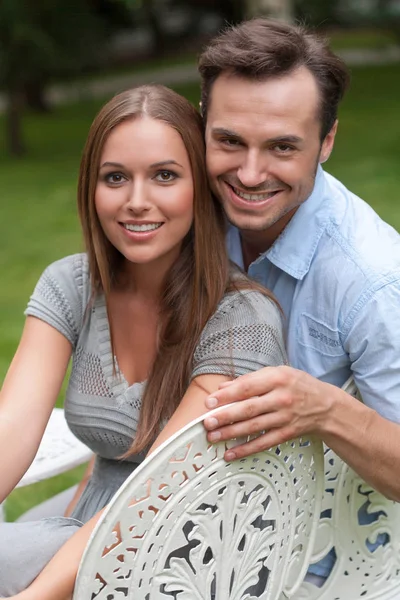 Couple sitting on chairs in park — Stock Photo, Image