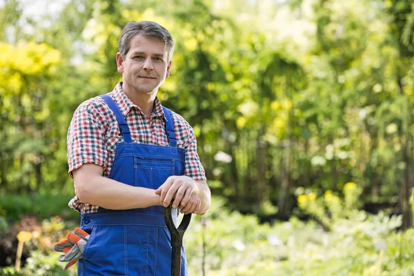 Confident gardener holding spade — Stock Photo, Image