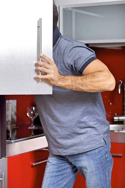 Young man looking in refrigerator