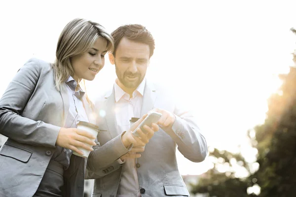 Casal de negócios usando telefone celular — Fotografia de Stock