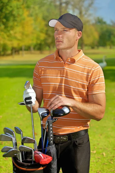 Hombre de pie junto a la bolsa de golf — Foto de Stock
