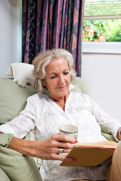 Senior kvinna läser bok — Stockfoto