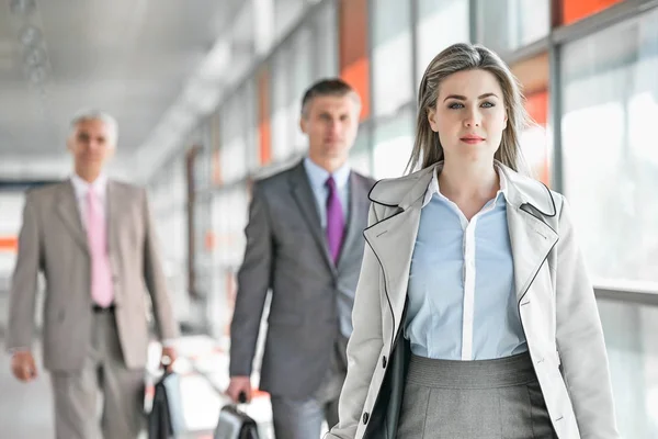 Mujer de negocios caminando con colegas masculinos — Foto de Stock