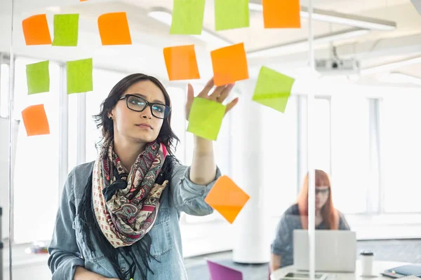 Business woman reading sticky notes — стоковое фото