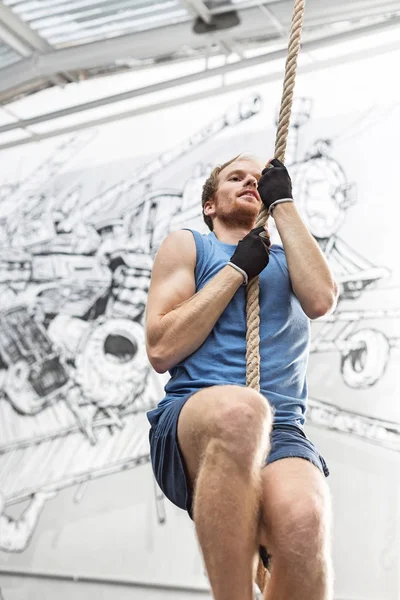 Determined man climbing rope — Stock Photo, Image