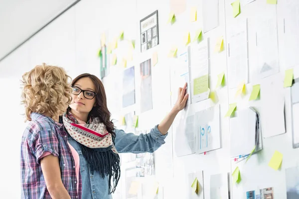 Creative businesswomen discussing over papers — Stock Photo, Image