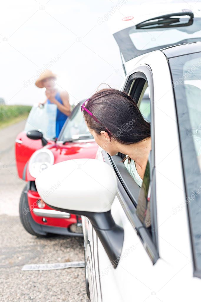Woman looking at female crashing car