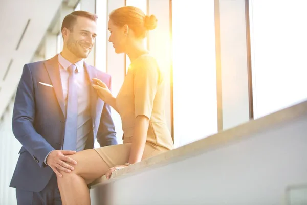 若い魅力的なビジネスカップルは黄色のレンズフレアとオフィスで愛情を示す — ストック写真