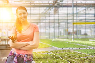 Sera içinde otlar karşı kadın botanikçi silah ile ayakta portresi gülümseyen güzel geçti