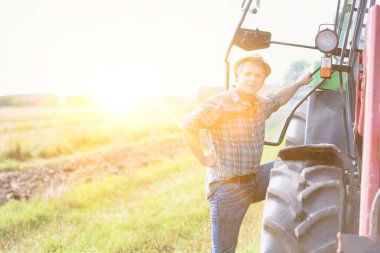 Güneşli bir günde çiftlikte hasatçının yanında bir adam.