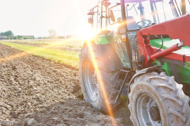 Arkaplanda sarı lens fişeği bulunan traktörün fotoğrafı
